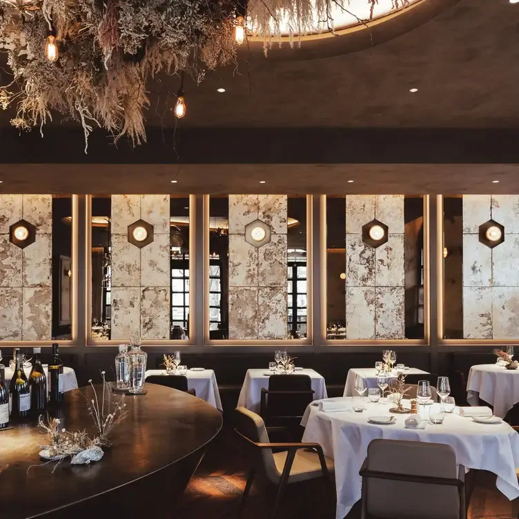 Warm tones, white tablecloths and a suspended floral display at The Ledbury in London