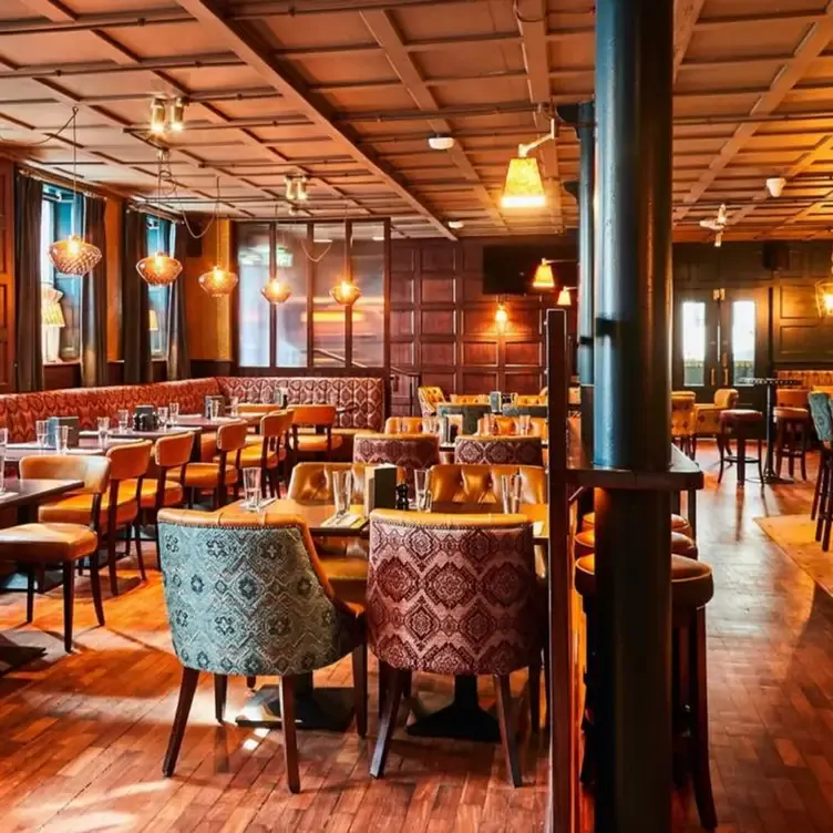 The interior of Purty Kitchen, showing intricately patterned cushioned chairs and booths and the wood-panelled walls and ceiling.