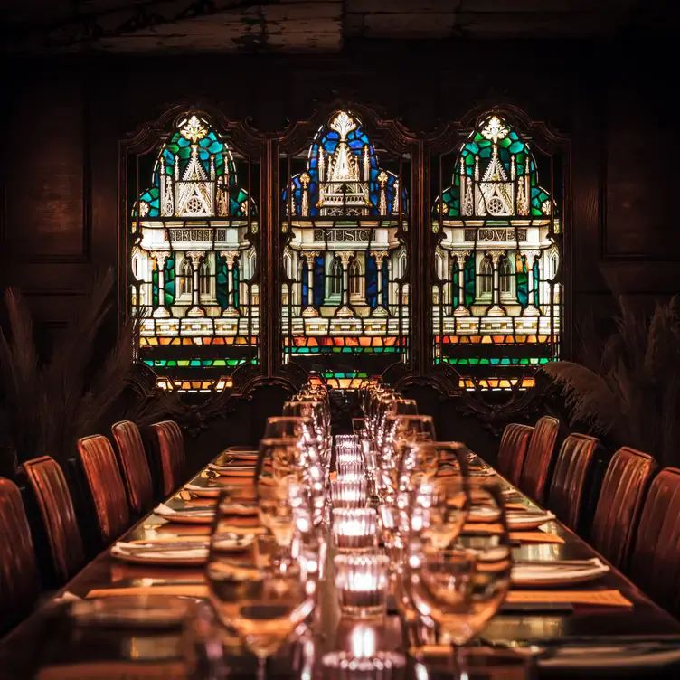 A long dining table and stained glass windows at The Blues Kitchen.