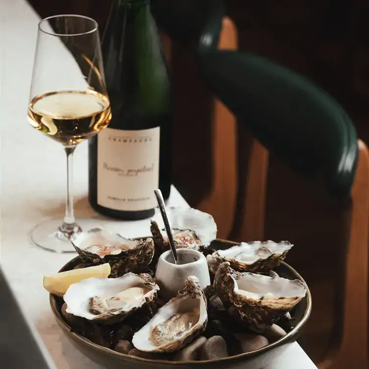 A platter of oysters with a bottle of wine at Stem and Stem - Restaurant and Florist