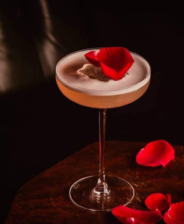 A cocktail topped with a rose petal at La Bibliothèque, one of the best Valentine’s Day restaurants in London