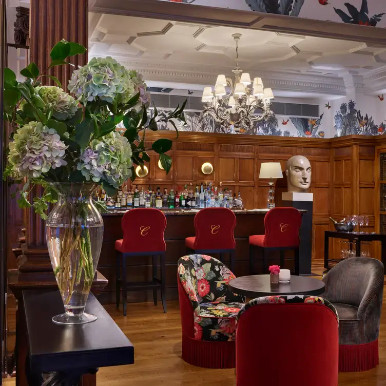 Comfortable seating area surrounded by flowers and art at the bar at Charlie’s, one of the best live music restaurants in London.