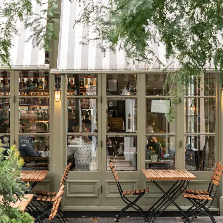 The external facade of a pub with glass windows and outdoor setting at The Thomas Cubitt Pub Belgravia