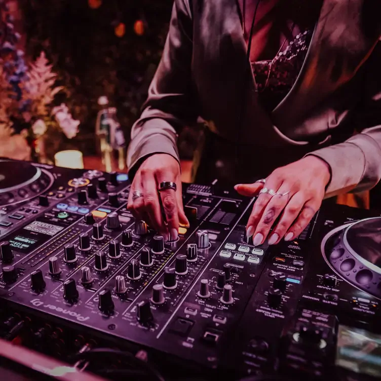 A DJ mixes music from a turntable at Bocconcino, one the best live music restaurants in London.