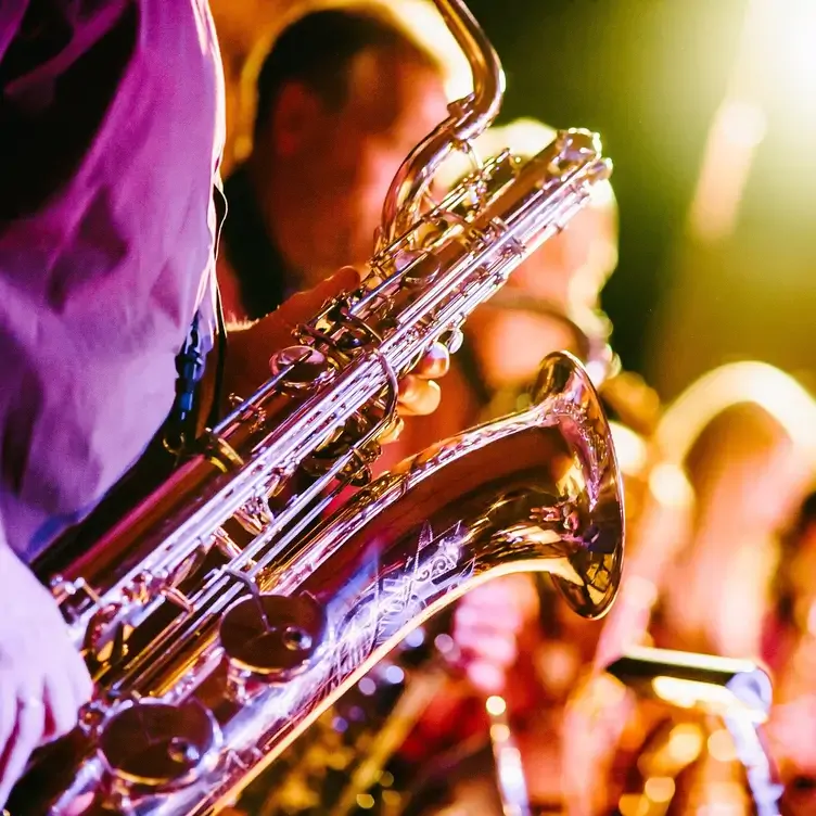 A close-up of a musician playing the saxophone at 28-50 By Night.