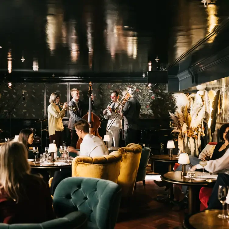 A live band plays on stage in the dining room at The Parlour at The Ned London, one of the best live music restaurants in London.