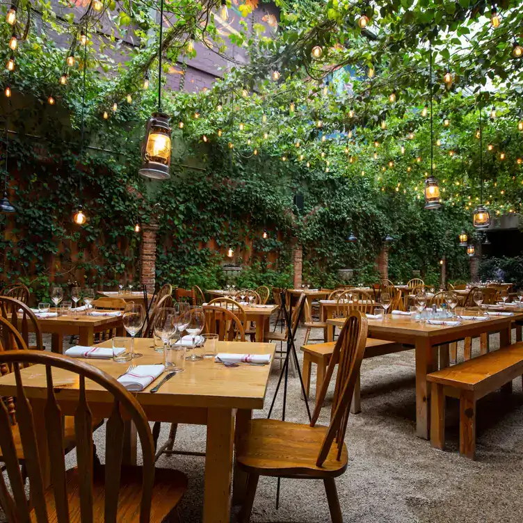 Interior view of Huset, one of the best restaurants in Mexico City, with wooden furniture and greenery.