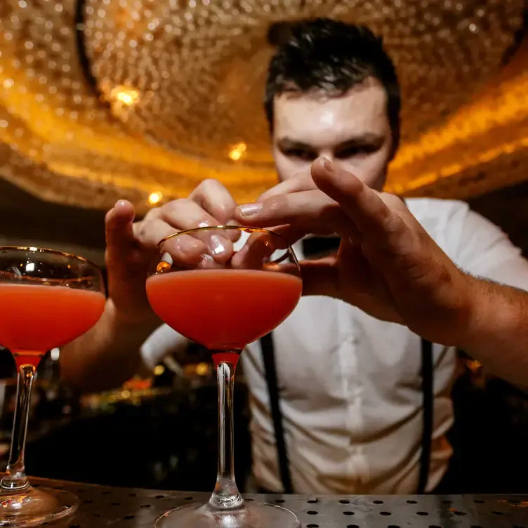 A mixologist prepares cocktails at the bar at 100 Wardour Street Drinks, one the best live music restaurants in London.