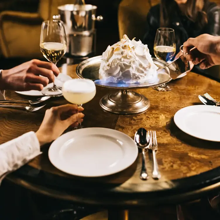 Diners enjoy wine, cocktails, and a dessert at The Parlour at The Ned London, one of the best music restaurants in London.