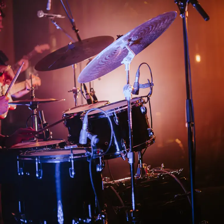 A set of drums being played during a live performance at Amazing Grace London, one of the best music restaurants in London.