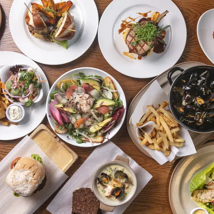 A number of dishes including mussels, lamb, salad and chips laid out on a table at The Schoolhouse Dublin.