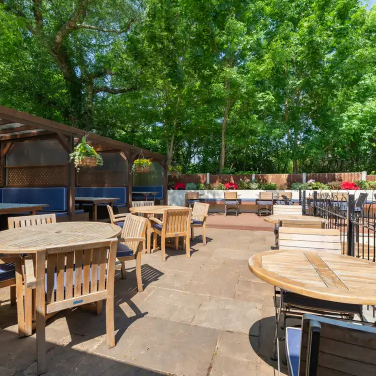 Tables and covered booths on the patio at The Bull, one of the best beer gardens in London.