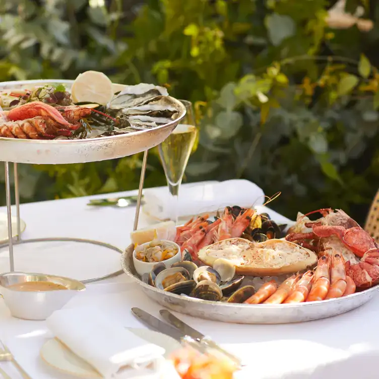 Shellfish platters sit on a table with a glass of champagne at Scotts Richmond.