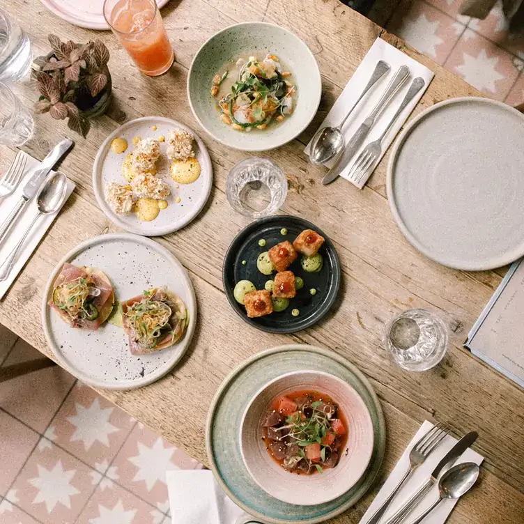 Ceviche dishes are accompanied by various small plates, glasses of water and fruit juice at Chicama, one of the best restaurants in Chelsea, London.