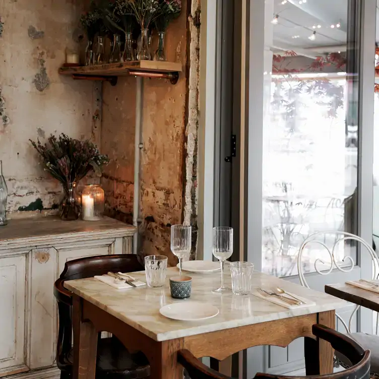 A table and chairs sits in the corner of the rustic dining room next to a door that opens onto the terrace at Chicama, one of the best restaurants in Chelsea, London.