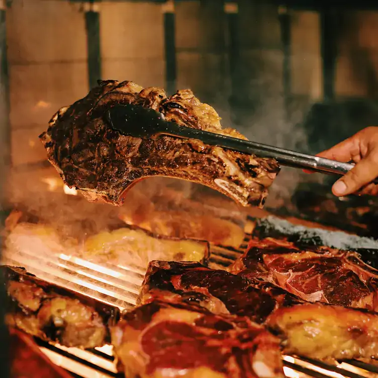 A lamb chop being roasted on the grill at Sagardi Basque Country Chefs, one of the best BBQ restaurants in London.