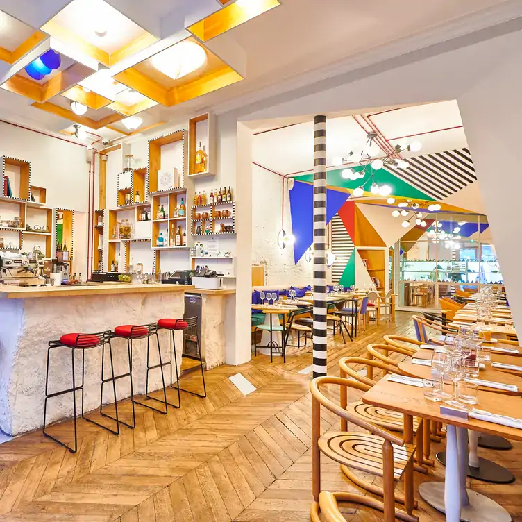 The interior of Mâche, showing the long dining space with large geometric pops of colour on the walls and ceiling.