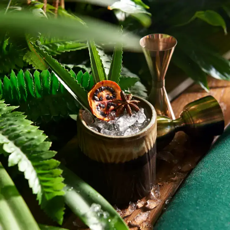 Cocktail over crushed ice, nestled within tropical leaves at Amazónico London, one of the best themed restaurants in London.