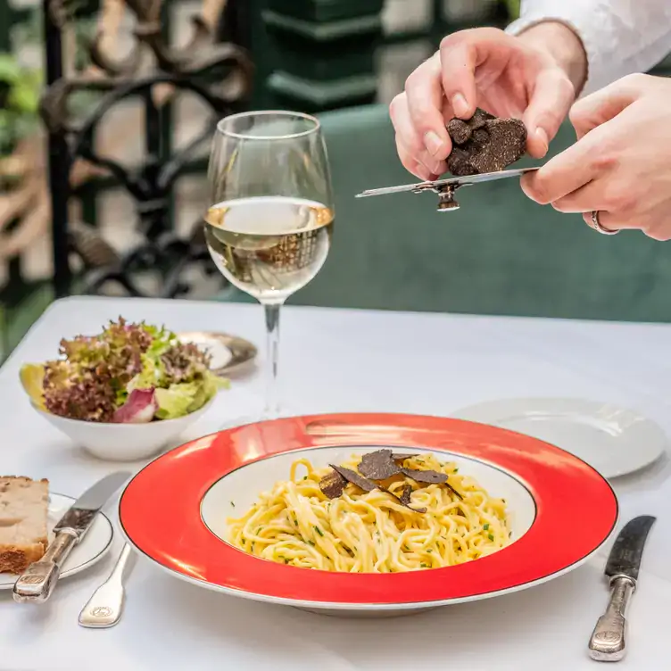 A waiter grates truffle on top of a spaghetti dish at Boisdale of Belgravia in London Victoria