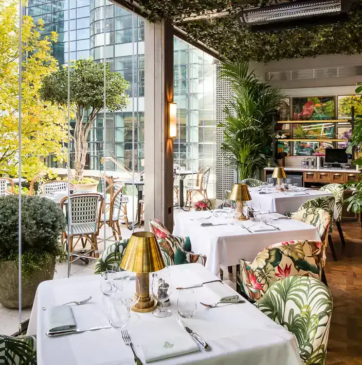 Interior of The Ivy in the Park, one of the best restaurants in Canary Wharf, showing the view through the picture windows.