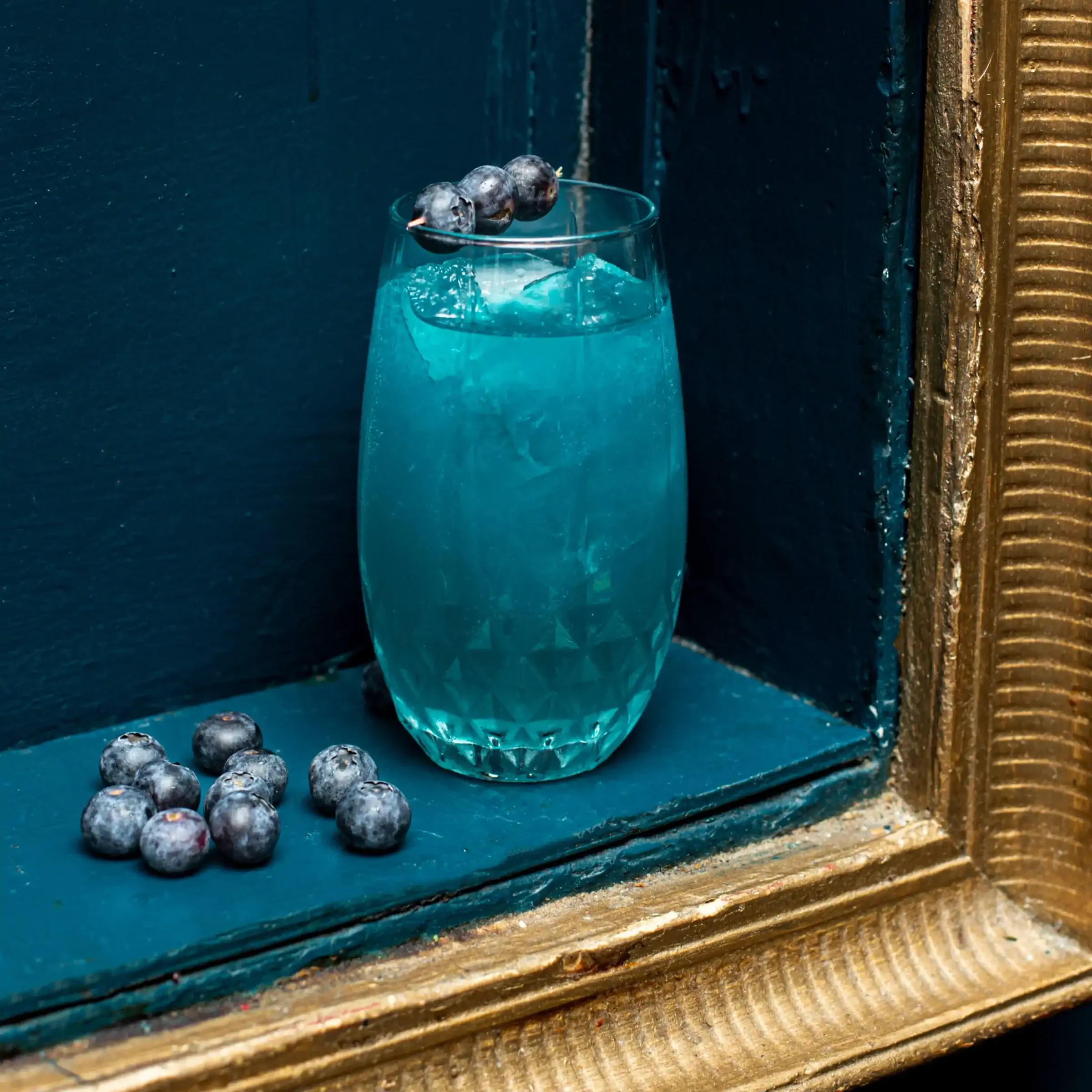 A blue cocktail with berries at L'Empire du 8ème in Paris