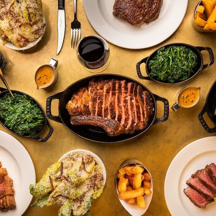 A steak pan sites in the centre of a spread of sides at Hawksmoor Edinburgh