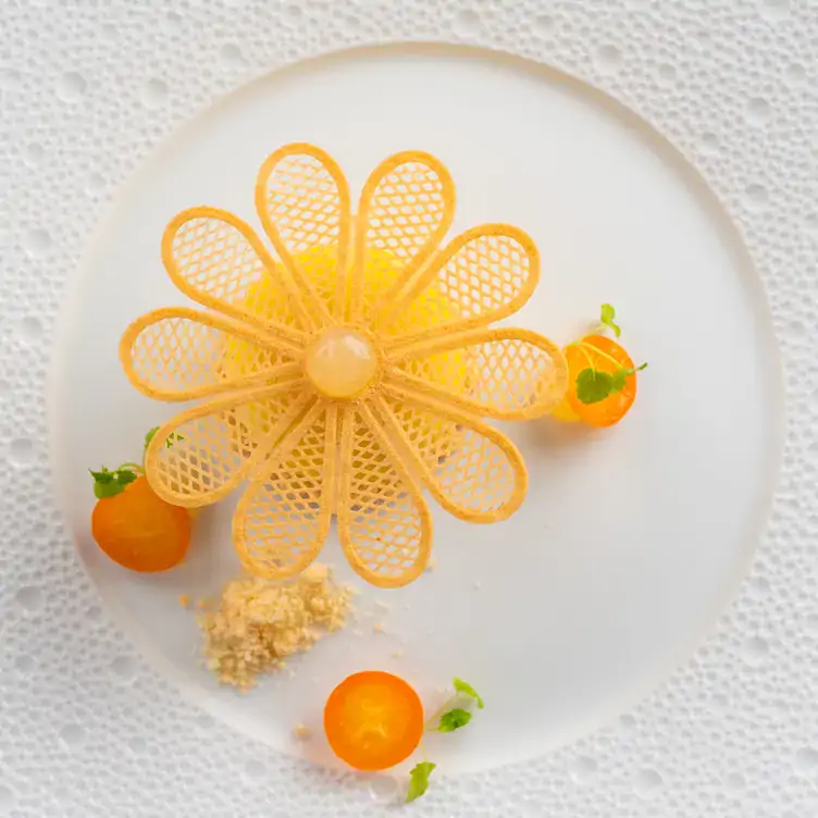 An appetizer with a floral decoration on a plate at Clos Maggiore, one of the most festive restaurants in the UK.