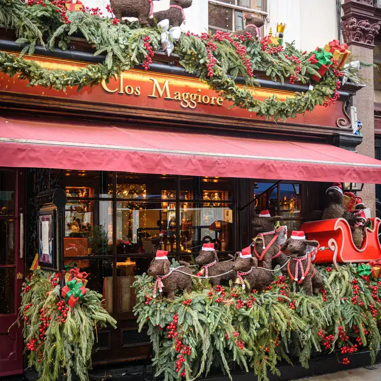 Entrance to Clos Maggiore, one of the best restaurants for Christmas dinner, with Christmas sleigh decorations and foliage.