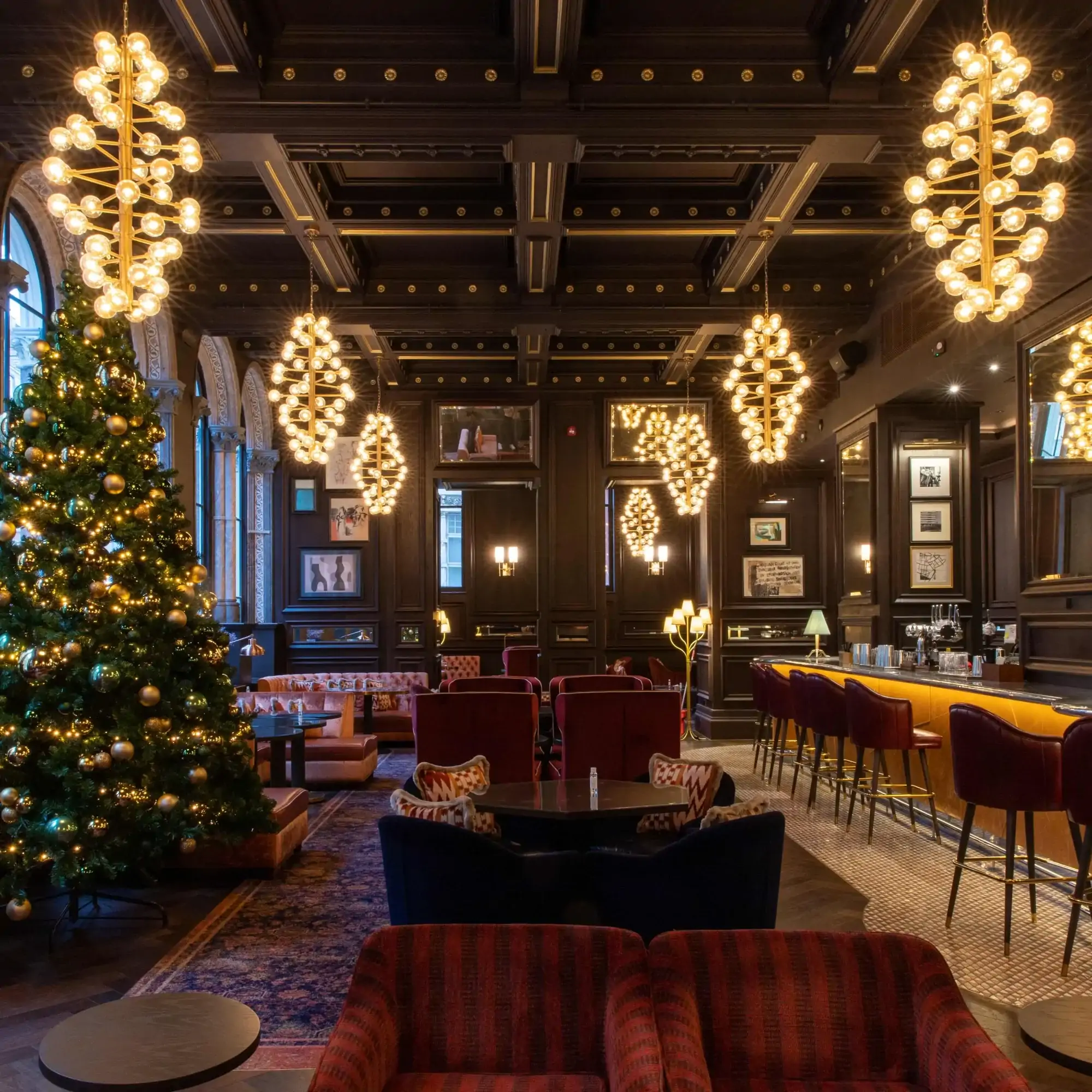 Bar area at Madeleine Bar at The Grand Hotel, one of the most festive restaurants in the UK, with Christmas tree and festive lighting.