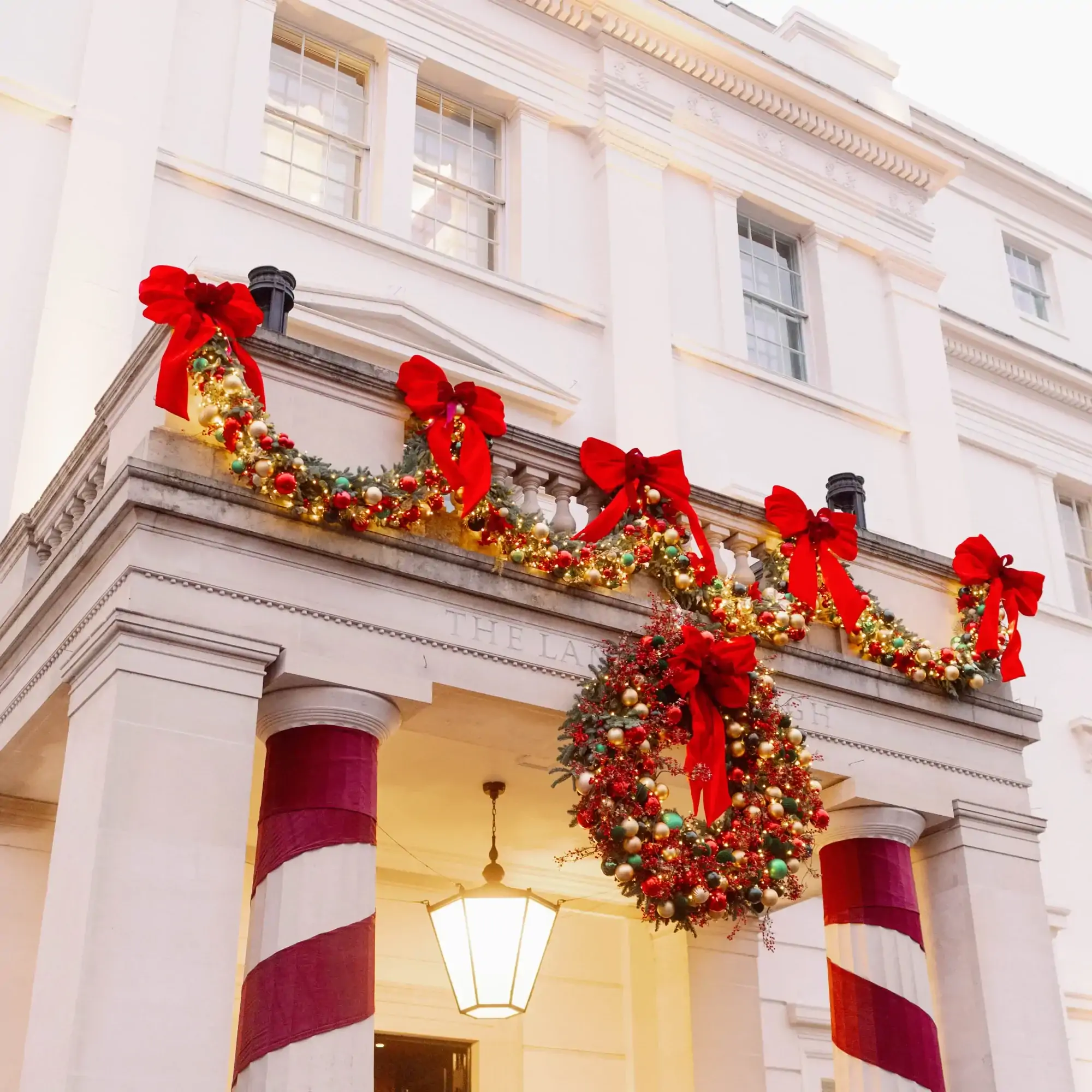 Entrance to The Lanesborough, one of the most festive restaurants in the UK, with Christmas wreaths around the doorway.