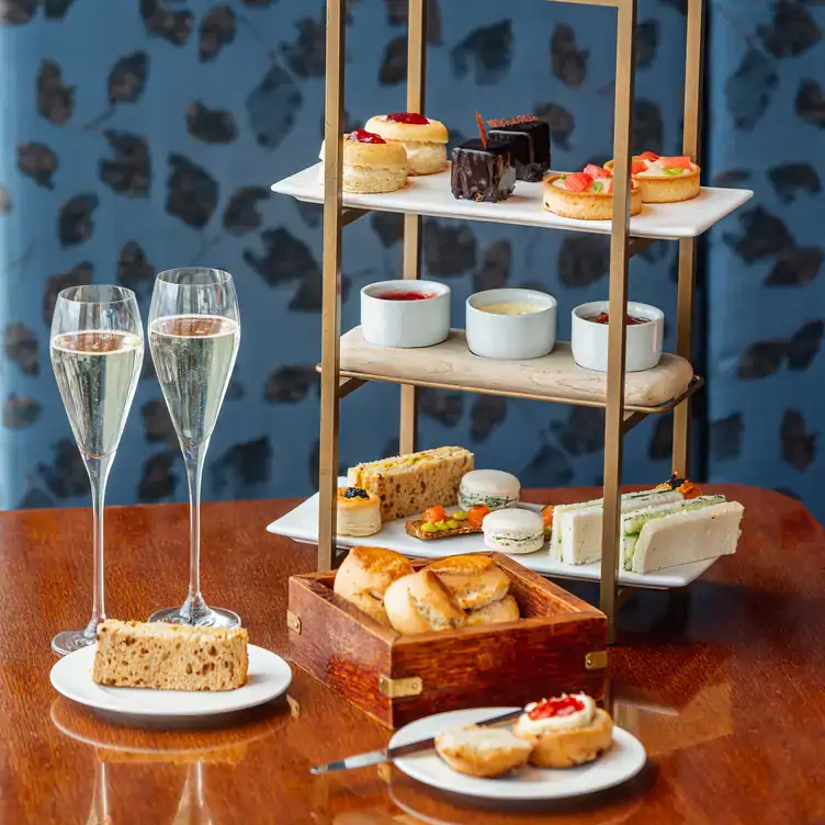 Afternoon tea on a three-tiered stand with two glasses of bubbly, from 20 Stories Restaurant, one of the best restaurants for Christmas dinner.