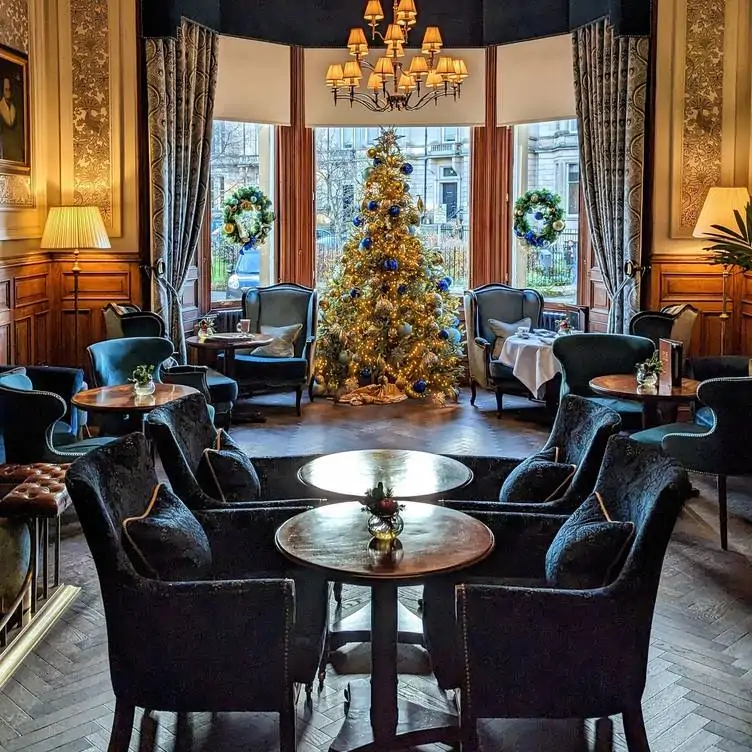 A bar and dining area at No. 35 at The Bonham, one of the most festive restaurants in the UK, with a Christmas tree in the window.