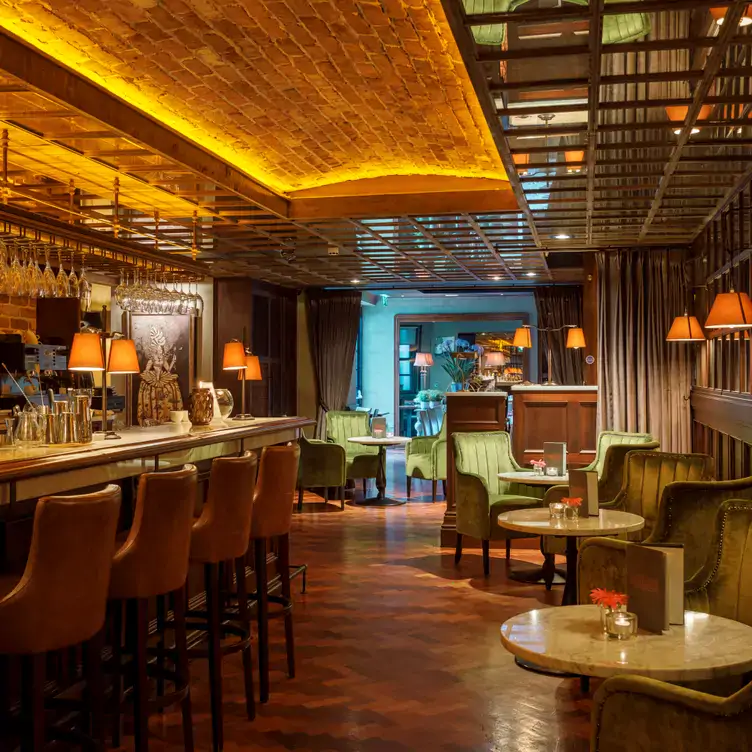 Bar and dining area at Suesey Street, one of the most festive restaurants in the UK, with bar stools and marble tables.