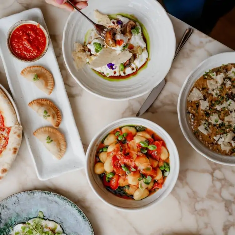 Various Japanese and Italian dishes on a table at May Fair Kitchen, one of the best gluten-free restaurants in London.