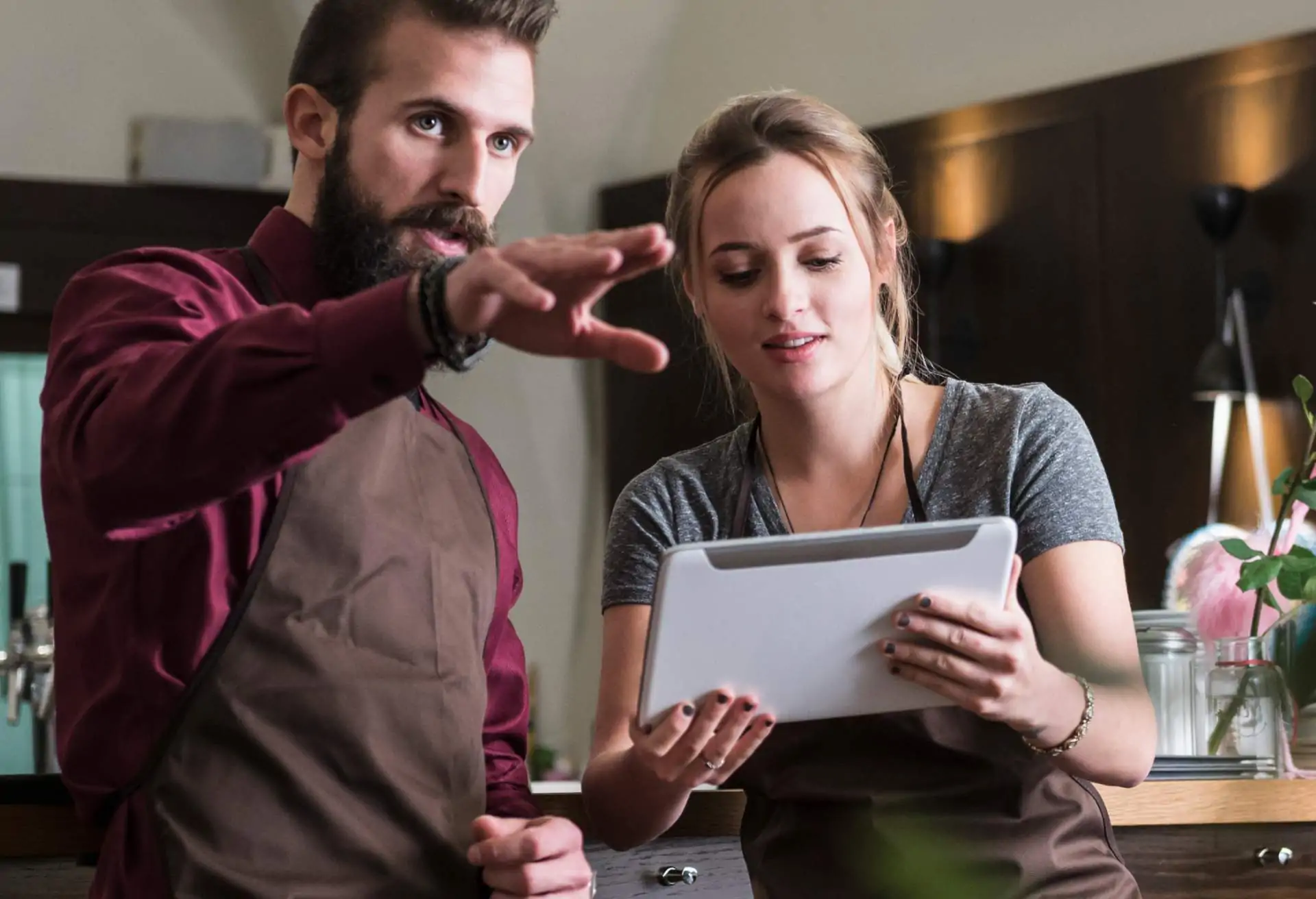 Two waiters checking a tablet device