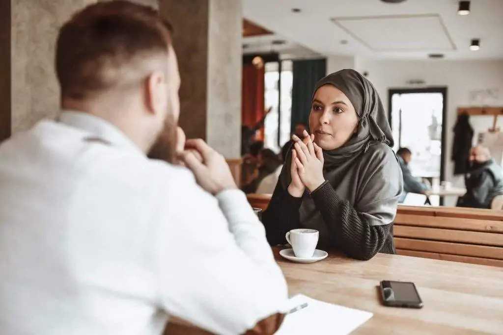 A restaurant manager interviews a candidate at a restaurant