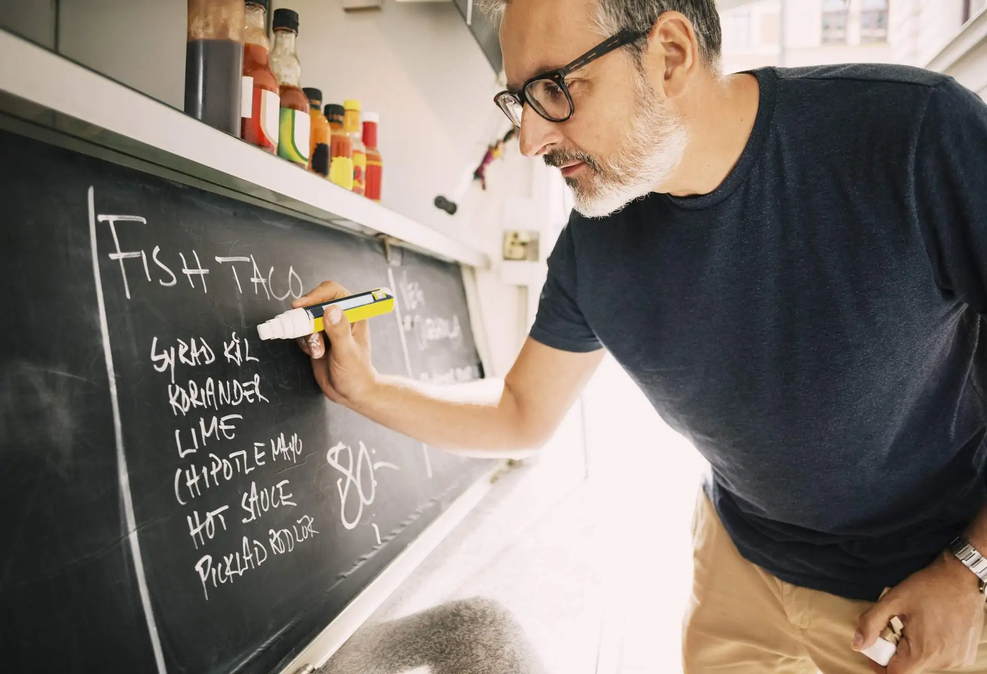 restaurant owner writing the menu on the board